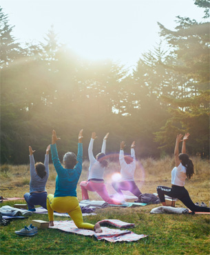 外でヨガをする人たちの写真